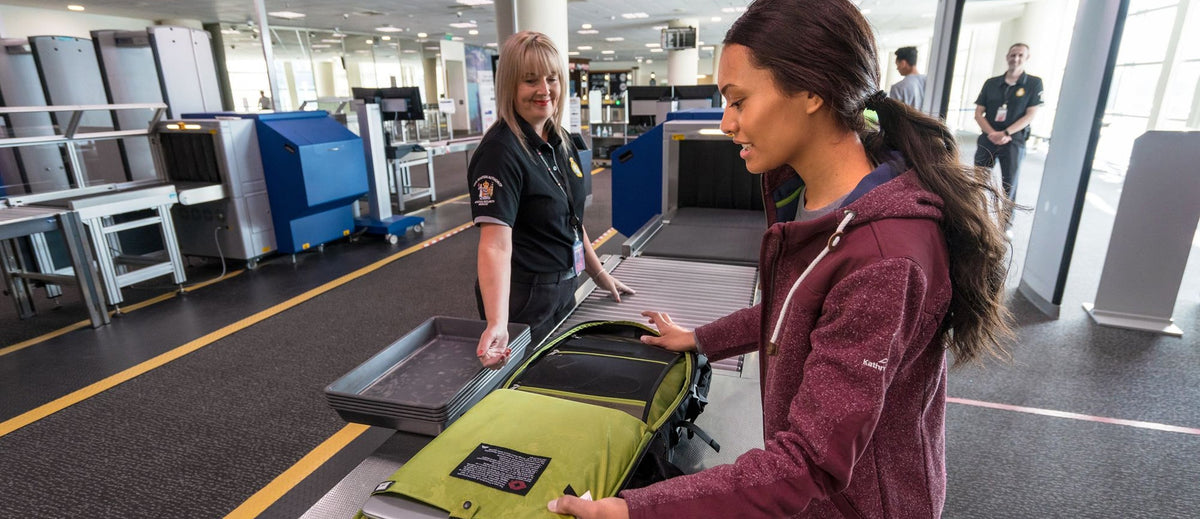 Woman checks her carry-on bag through customs